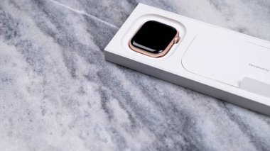 Jurmala, Letonya 21.01.2025: Yakın plan New Apple Watch serisi 10 Rose Gold. Zarif bir ukala beyaz ambalajının üzerinde uzanır, modern tasarımını ve zarif renklerini desenli