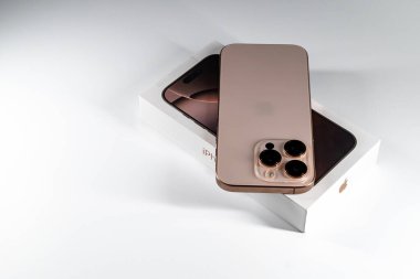 Jurmala, Letonya - 31.05.2025: Apple Iphone 16 Pro Desert Titanium beyaz arka planda. Yeni Iphone 16 Pro in Desert Titanium, parlak ambalajında belirgin bir şekilde sergilenmektedir. - Evet. Yüksek kalite fotoğraf