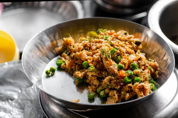 Oats upama home made in the stainless steel plate with green peas and vegitanles added as a morning breakfast during dieting. Used selective focus.