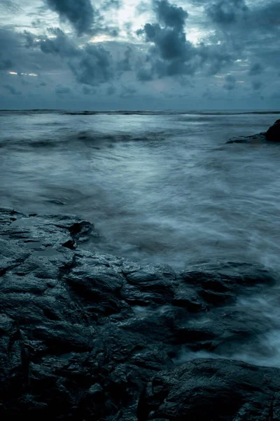 stock image Cloudy evening during blue hour with seas shore and waves.