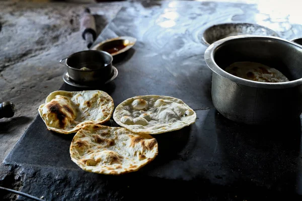 stock image Three Tandoor roti freshly made to serve in the punjabi dhaba with utensils near it. Selective focus.