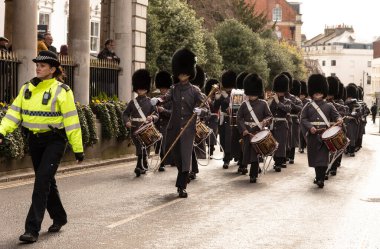 Windsor, Berkshire, İngiltere, İngiltere. 2023. Davul Kolordusu, 1. Tabur Galli Muhafızlar, Windsor, İngiltere 'deki Kılavuz Salonu' nun yanından geçen bir kadın polis tarafından yönetiliyor..