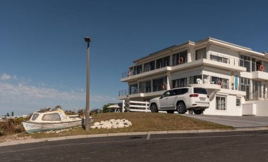 Yzerfontein, Batı Kıyısı, Güney Afrika. 2023. Güney Afrika 'nın batı kıyısında modern evler. Teknesi ve garaj yolunda beyaz bir 4x4 arabası var..