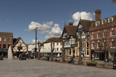 Salisbury, Wiltshire, İngiltere, İngiltere. 2023. Kent merkezindeki Pazar Yeri 'nde tarihi binalar, dükkanlar ve ofislerle çevrili insanlar yürüyor.