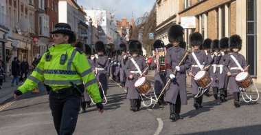 Windsor, Berkshire, İngiltere, İngiltere. 2023. Windsor şehir merkezi boyunca Galli muhafızların bando şeflerine liderlik eden kadın polis..