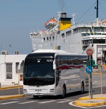 Heraklion, Girit, Yunanistan, AB. 2023. Arka planda Heraklion limanından ayrılan beyaz tur otobüsü adalar arası feribot yanında..