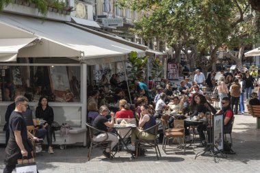 Heraklion, Girit, Yunanistan, AB. 2023. Heraklion şehir merkezine gelen müşteriler ve ziyaretçiler açık hava restoranları ve kafelerde öğle yemeğinin tadını çıkarıyorlar. Şehir merkezi, iş,