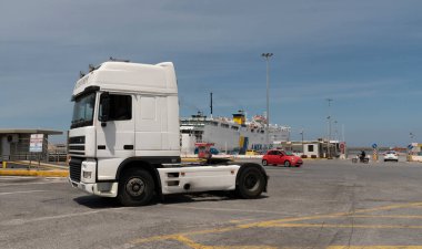 Heraklion, Girit, Yunanistan, AB. 2023. Limandan ayrılan beyaz renkli bir traktör bir karavanı feribota bindirmiş..