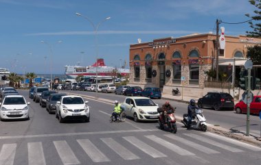 Heraklion, Girit, Yunanistan, AB. 2023. Tekerlekli sandalyedeki engelli kişi liman bölgesindeki yük vagonunu geçmeye çalışıyor..