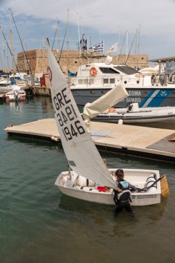 Heraklion, Girit, Yunanistan, Avrupa. 2023. Genç çocuk Girit, Heraklion 'daki eski limanda yelkenli dersine hazırlanıyor..