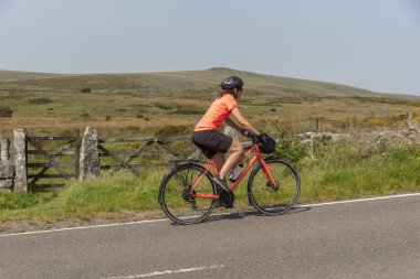 Dartmoor, Devon, İngiltere, İngiltere. 4 Eylül 2023. Dartmoor Ulusal Parkı 'nda bisiklet turunda olan kadın bisikletçi Devon, İngiltere, İngiltere.