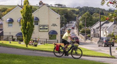 Princetown, Dartmoor, Devon, İngiltere. 6 Eylül 2023. Dartmoor, Devon, İngiltere 'de Princetown Lisesi' nden geçen bisikletçi..