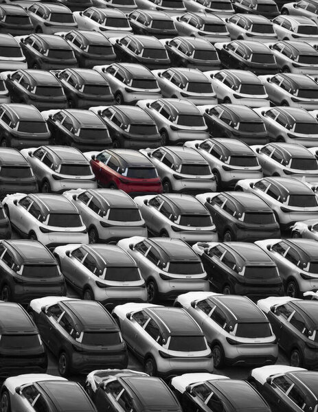 Zeebrugge Belgium Europe. 21.12.2024. A red car among new cars parked on the dockside for export and import in. the motor trade.