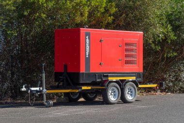 Paarl, Wesstern Burnu, Güney Afrika. 13.04. 2024. Kırmızı boyalı dizel motorlu jeneratör dört tekerli bir römorka monte edilmiş, taşınmaya hazır..