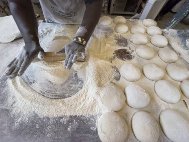 Yzerfontein Batı Cape Güney Afrika 'da. 19.04.2024. Hamur toplarından pizza yapmak için hamur işi yapan fırıncı..
