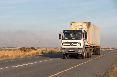 Batı Burnu, Güney Afrika. 24.04. 2024. Batı Burnu 'nun Swartland bölgesinde otoyol boyunca giden bir kamyonda metal bir nakliye konteynırı..