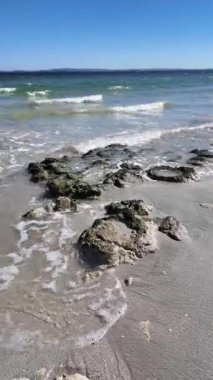 Langebaan, batı kıyısı, Güney Afrika. 24.04.2024. Deniz kıyısında göl kıyısı. Gelen gelgit kumlu sahilde kayaları yıkıyor..