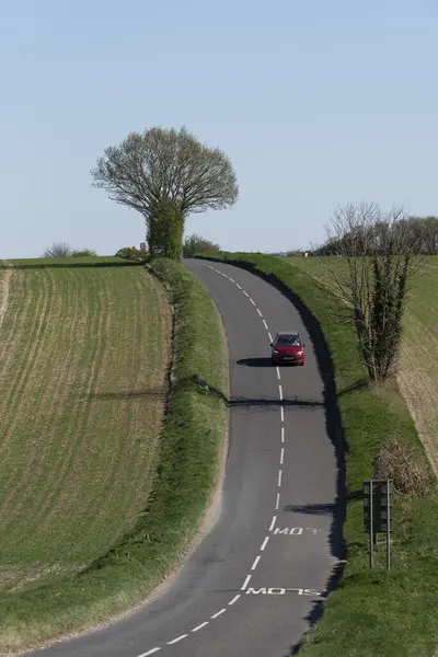 Hampshire İngiltere. 04.04.2025. İngiltere 'de Hampshire' da İngiliz köy yolunda kırmızı bir araba..