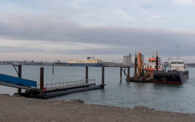 İngiltere 'nin Southampton Su İşleri. 09.03. 2025 yılı. Dalgıç teknesi ve mavna Southampton 'da çalışıyor. Hythe' ye yakın bir yerde, bu su yolunun batı kıyısında..