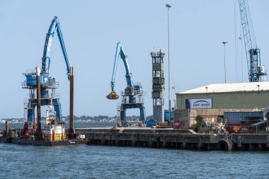 Poole Dorset İngiltere. 17.08.2025. Poole Dorset Limanı, rıhtımda vinçleri olan malzeme işleme alanı.