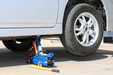 Araba bir kriko tarafından kaldırılır. Fotoğraf yakın plan..