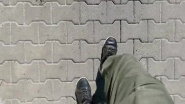 Spor ayakkabılı erkek bacakları kaldırımdaki parktaki yolda yürüyor..