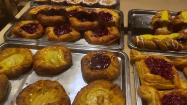 Mağazadaki raflarda taze hamburgerler. Kahvaltı için nefis sıcak hamur işleri tezgahın arkasında. Kapatın.