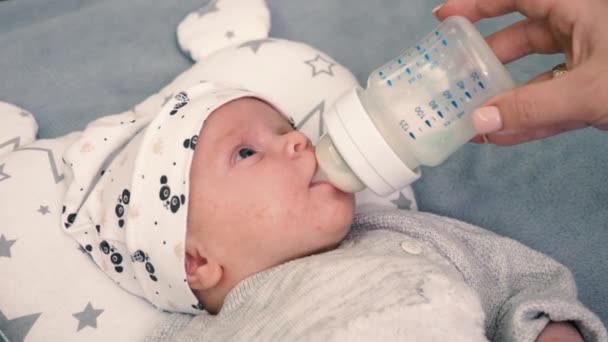 엄마는 아기를 키우고 귀엽고 돌보고 있습니다 우유를 마시고 병에서 태어난 — 비디오