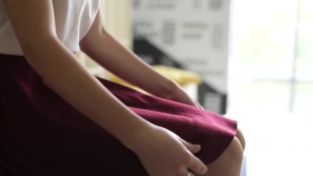 年轻的女学生坐着很紧张 在腿和裙子的框架内 不确定的行动 — 图库视频影像
