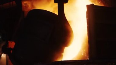Çelik fabrikasında erimiş metalden yapılmış demir kepçe dök.