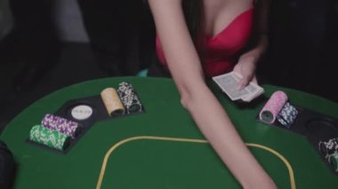 Genç bayan poker masasındaki oyunculara kart dağıtıyor. Kumarhane, para için kumar. Eğlence Bağımlılığı.