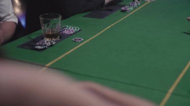 Poker masasında kumar oynayan adamlar. Kadın oyunculara kart dağıtır. Her oyuncuya masaya fırlatır.