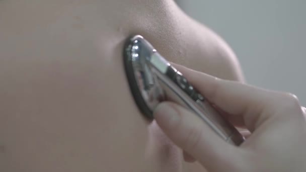 女医生在临床上使用听诊器 同时用听诊器对着男病人的背听呼吸 — 图库视频影像