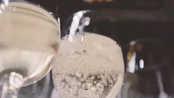侍者把白葡萄酒倒在玻璃杯里 在庆祝活动上 酒保在酒瓶中倒入香槟招待客人 — 图库视频影像