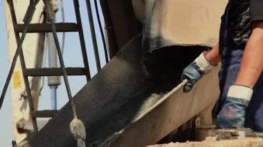 İnşaat işçileri çimento kamyonundan beton döküyorlar. Evin inşaatı için vakfın inşaatı