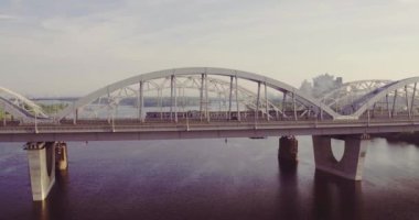 Kiev köprüsü ve yolu. Şehrin havadan çekimleri, arabalar ve yazın nehir manzarası..