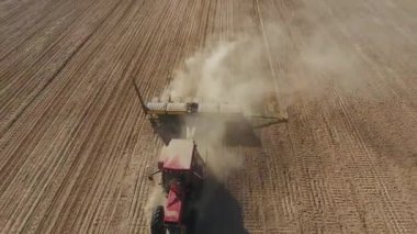 Tarlaya mısır ve buğday ekmenin havadan görünüşü. Bir traktör şirketin tarlasına tahıl ekiyor.