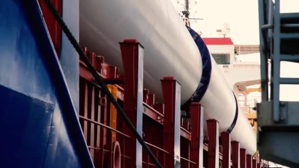 環境エネルギーのための巨大な風車ブレードは 荷降ろしのための港で大きな配達貨物船にあります — ストック動画