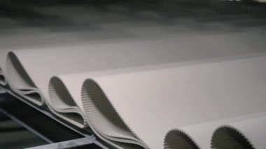 Manufacture of cardboard boxes. Enterprise for the production of cardboard packaging. Close-up of a row of pleated cardboard on a conveyor belt
