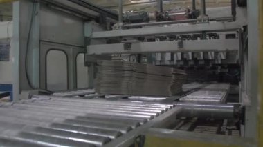 finished cardboard boxes packed in bundles are transported along a production line conveyor at a paper mill. Ukraine, Kiev 2019
