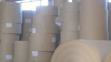 Kraft karton ve kutu üretim deposunda büyük kahverengi kağıt tezgahları var.