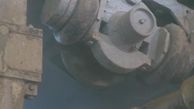 Mechanism in motion in the form of a gimbal in a cardboard box factory. Lots of paper dust. Part on pneumatic rubber pads