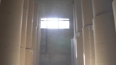 Daha fazla bükülmüş kutu yapmak için depoda büyük rulo kağıt standları var.