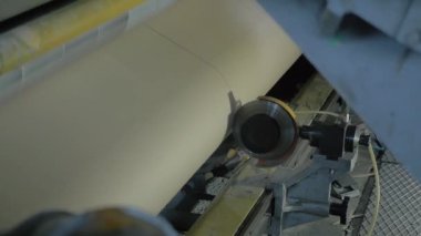 Otomatik bıçak modern kağıt kutusunda kahverengi karton kağıt rulo kesiyor.