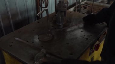 Demirci, metal çubuğu otomatik örsün üzerine eğip sarmal, kapıda dekoratif süslemeler, sahte metaller yapar.