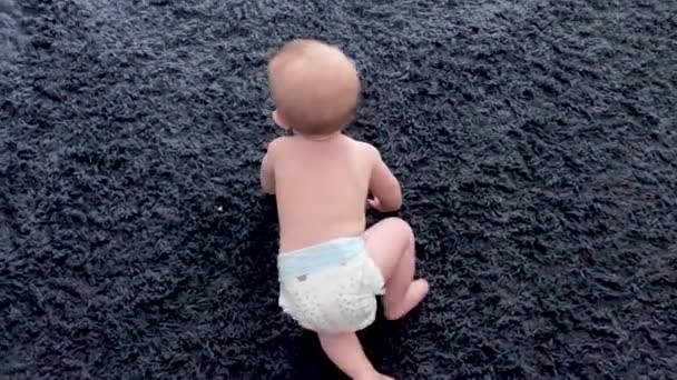 아기는 부모에게 바닥을 가로질러 기어갑니다 행복한 아기는 배우기 시작합니다 — 비디오