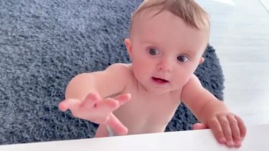 Mutlu bebek dairede ilk adımlarını atmayı öğreniyor. Masadaki bir şeye uzanmaya çalışıyorum.