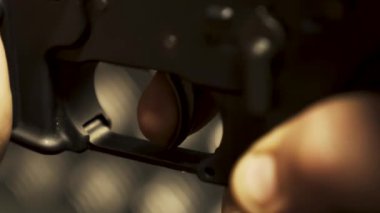 Pulling the trigger on a machine gun close-up of a hand-held firearm