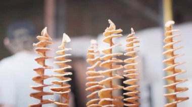 Spiral potato chips on a stick at a street food restaurant. Close-up.