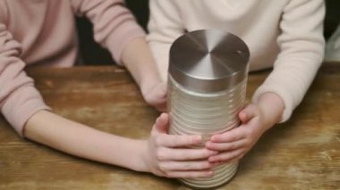Kids and mom scatter flour on the table spreading it with their hands. mom teaches kids how to make bread. Happy family in the kitchen